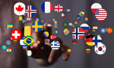 A hand pointing at a diverse collection of country flags, symbolizing international relationships, global connections, and the concept of worldw