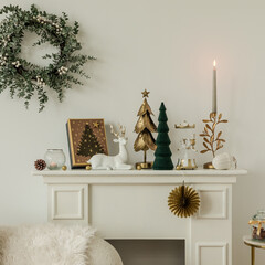 Festive mantel decor with green trees, gold candleholder and holiday wreath. Sophisticated and...
