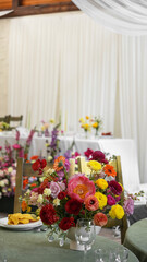 colorful wedding ekibana in vase on wedding tables in hall . Wedding flower arrangement. Ranunculus, gerbera, rose, carnation