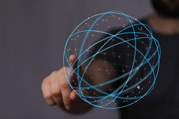Person interacting with a glowing sphere of connected lines and dots. Represents global communications, internet, technology, and digital transf © vegefox.com