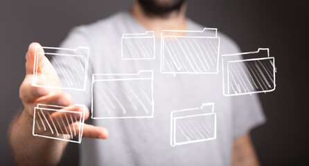 A man's hand reaching toward digitally drawn folders. Concept of data, information, management, and...