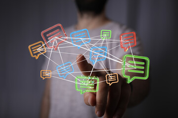 A hand touching floating speech bubbles, illustrating communication, social media, and networking concepts in technology.  Shows connection and