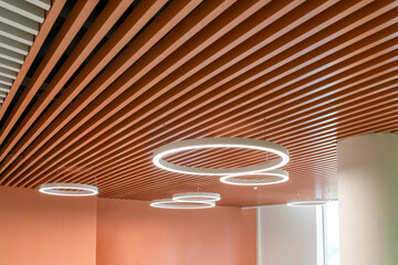 Wooden panels and round lights Circular pendant lights on wooden slats, modern ceiling interior...