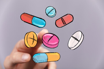 Image of hand interacting with colorful pills and capsules.  Perfect for healthcare, medicine, and pharmacy concepts.