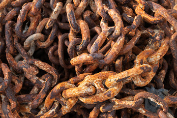 Old rusty naval chain is on the pier, close up photo