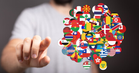 Person touching or interacting with a collection of flags representing nations worldwide, symbolizing global connection and communication