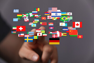 A hand interacting with a network of flags representing different countries, symbolizing global...