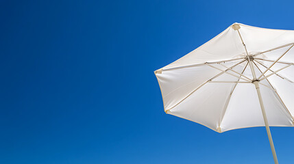 Parasol on a sunny beach providing shade. Summer getaway, vacation, and relaxation concept. The sky is vibrant blue, creating a serene atmosphere.