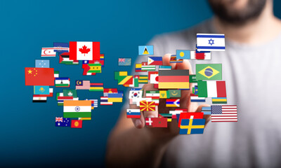 A person holding up a collection of flags representing different nations, diversity, global community, and internationalism. This image symboliz