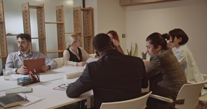 A diverse team of business colleagues collaborates on marketing statistics and brainstorms ideas for small business growth and profitability. - Powered by Adobe