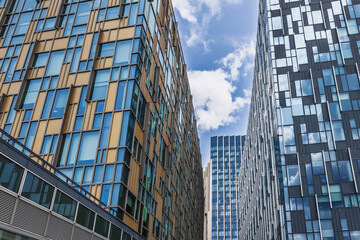 Modern glass skyscrapers with geometric facades and reflections