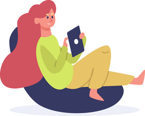 Young woman relaxing on bean bag using tablet