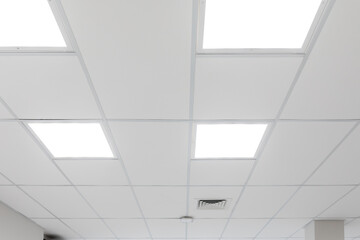 White ceiling with panel lighting. Light panels integrated in suspended ceiling, neutral colour...