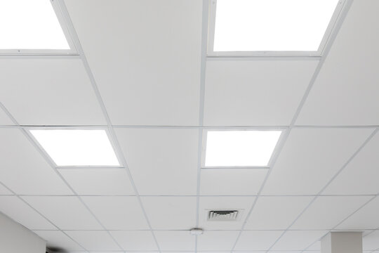 White ceiling with panel lighting. Light panels integrated in suspended ceiling, neutral colour temperature, optimal office lighting. Real photo