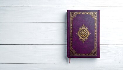Fototapeta premium A close-up photograph displays a hardcover book, resting on white wooden planks. The book?s cover is dark purple with gold embellishments