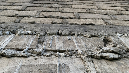Weathered gray cinder block wall featuring thick, rough mortar joints and a heavily textured surface suitable for use as an industrial background. Abstract concept