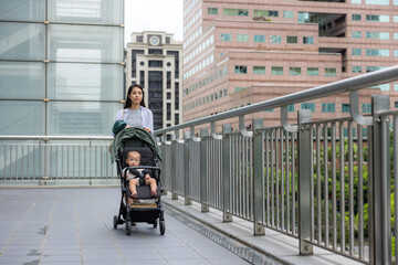 Obraz premium Mother carrying her baby through city streets