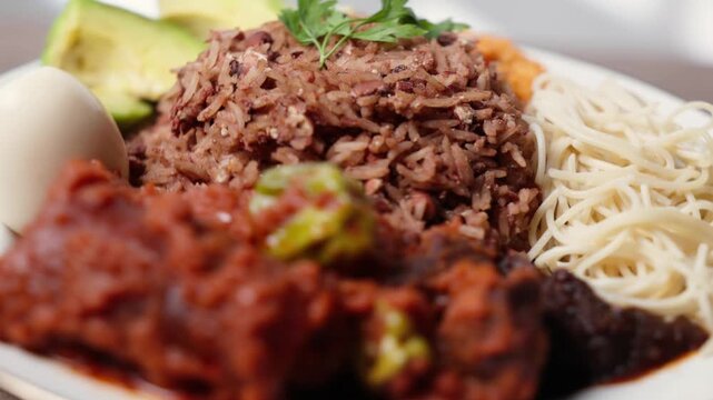 Waakye, Cooked Rice And Beans Served With Tomato Stew, Egg, Gari, Spaghetti, Avocado and Shito, Spicy Pepper Sauce. Africa Ghana Traditional Dish