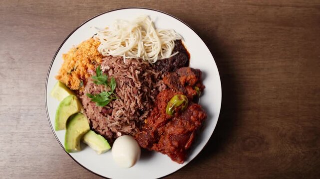 Waakye, Cooked Rice And Beans Served With Tomato Stew, Egg, Gari, Spaghetti, Avocado and Shito, Spicy Pepper Sauce. Africa Ghana Traditional Dish