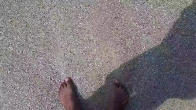 POV feet playing in clear seawater at Angso Duo Island beach Pariaman Indonesia