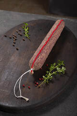 Dry-cured and smoked sausage on a dark background