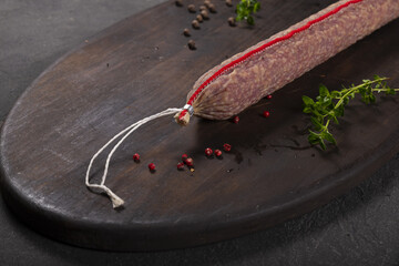 Dry-cured and smoked sausage on a dark background