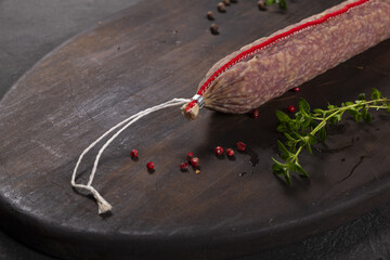 Dry-cured and smoked sausage on a dark background