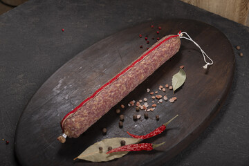 Dry-cured and smoked sausage on a dark background