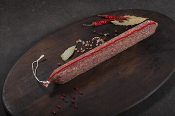 Dry-cured and smoked sausage on a dark background