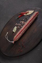 Dry-cured and smoked sausage on a dark background
