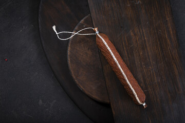 Dry-cured and smoked sausage on a dark background