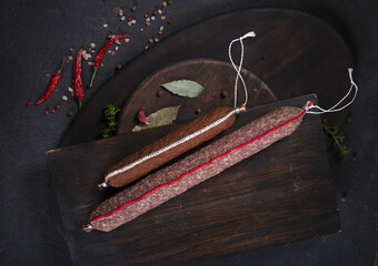 Dry-cured and smoked sausage on a dark background