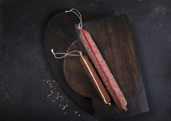 Dry-cured and smoked sausage on a dark background