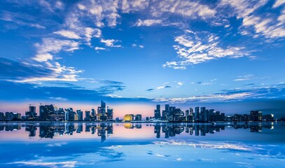 Obraz premium Cityscape Reflection on Water at Dusk with Twilight Blue Sky Panorama