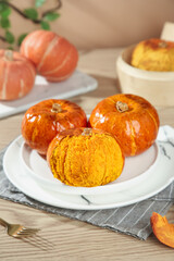 Fresh Autumn Pumpkins and Seasonal Squash Varieties on White Plates - Fall Harvest Display