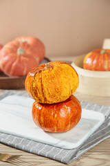 Small Fresh Orange Pumpkins Cut Open Showing Golden Flesh on Marble Board - Autumn Harvest Vegetables