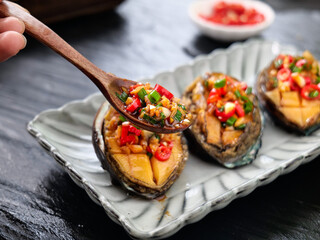 Steamed Abalone with Garlic and Chili - Premium Seafood Delicacy on Traditional Serving Plate