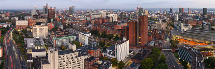 Aerial panorama of Manchester skyline at dawn above the Mancunian Way, with Stockport Road and the city centre.