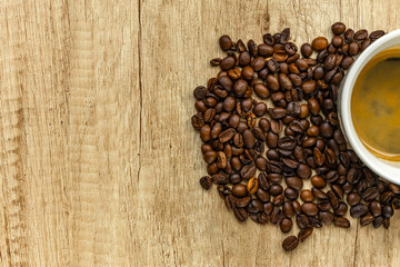 Rising Coffee Prices Concept with Cup and Spilled Coffee Beans on Wooden Table