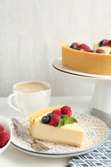 Delicious cheesecake with fresh berries and mint served on white table