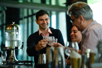 Coworkers relaxing and talking over drinks in luxury rooftop bar, representing concept of corporate event, teamwork, social gathering, and lifestyle enjoyment.
