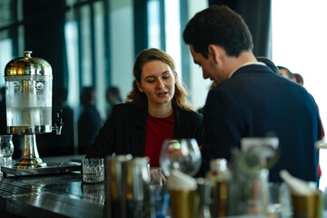 Two colleagues enjoying friendly conversation and drinks at stylish rooftop bar, representing business networking, partnership building, and positive work-life balance concept.