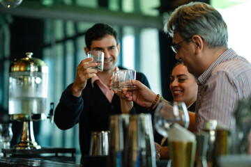 Multinational business professionals enjoying drinks after meeting, highlighting work-life balance, team bonding, and networking in a sophisticated bar environment.