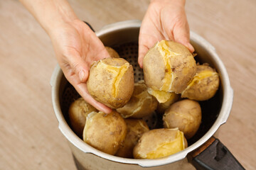 Fresh Cooked Yellow Potatoes from Gansu China in Hands Over Cooking Pot