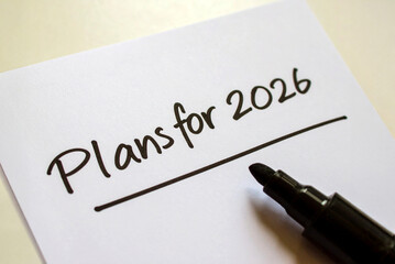 New year intention setting. Plans for 2026. Handwritten marker inscription on a white sheet of paper standing on the table, close-up