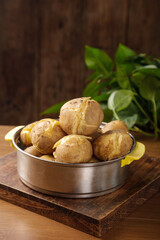 Boiled Potatoes with Fresh Herbs in Rustic Kitchen Setting on Wooden Board