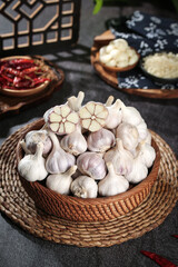 Fresh White Garlic Bulbs in Wicker Basket with Traditional Asian Cooking Ingredients