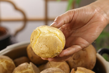 Fresh Baked Potato with Golden Crispy Surface Held in Hand - Homemade Comfort Food