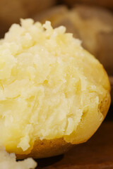 Steaming Hot Baked Potato with Fluffy White Flesh on Wooden Background