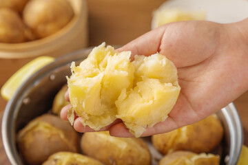 Hand Holding Steamed White Potato with Fluffy Interior - Fresh Cooked Comfort Food